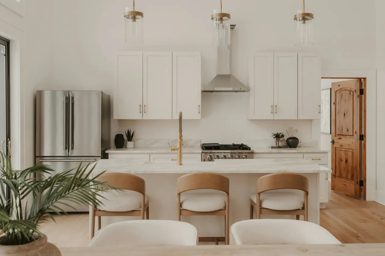 Modern white kitchen with stainless steel appliances — showroom reference